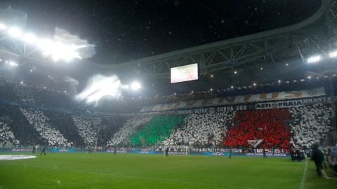 Supporters wave flags under an heavy rain prior the Champions League match Juventus vs Celtic FC on March 6, 2013   at the "Juventus Stadium" in Turin.  AFP PHOTO / MARCO BERTORELLO        (Photo credit should read MARCO BERTORELLO,MARCO BERTORELLO/AFP/Getty Images)
