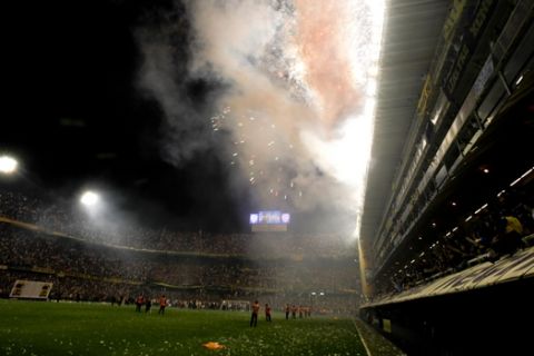 Police stand on the field of  Bombonera stadium as Boca Juniors' fans celebrate winning Argentina's soccer league championship title after defeating  Banfield 3-0 in Buenos Aires, Argentina, Sunday Dec. 4, 2011. (AP Photo/Natacha Pisarenko)