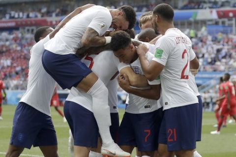 England players run to teammate John Stones after he scored his team's first goal during the group G match between England and Panama at the 2018 soccer World Cup at the Nizhny Novgorod Stadium in Nizhny Novgorod , Russia, Sunday, June 24, 2018. (AP Photo/Matthias Schrader)