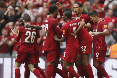 Liverpool players mob Liverpool's Joel Matip as they celebrate after he scored his sides 1st goal during the Community Shield soccer match between Manchester City and Liverpool at Wembley Stadium in London, Sunday, Aug. 4, 2019. (AP Photo/Frank Augstein)