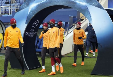 Roma's Bruno Peres, second left, Gerson, center, and teammates take to the pitch prior to a team training session in Kharkiv, Ukraine, Tuesday, Feb. 20, 2018. Roma will play against FC Shakhtar Donetsk in a Champions League, round of 16, first-leg soccer match in Kharkiv, Wednesday.  (AP Photo/Efrem Lukatsky)