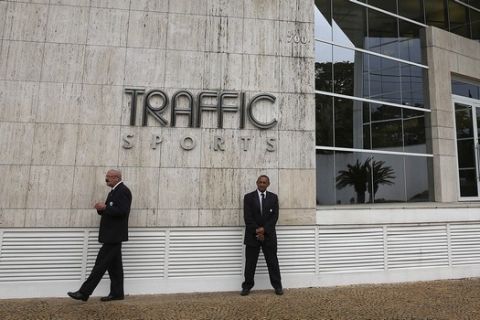Private security guards stand outside the headquarters of sports marketing company Traffic Sports, in Sao Paulo, Brazil, Thursday, May 28, 2015. U.S. officials say Jose Hawilla, the owner of the Brazil-based sports marketing firm, is one of four men who has pleaded guilty in the U.S. soccer corruption investigation involving bribes totaling more than $100 million. (AP Photo/Andre Penner)