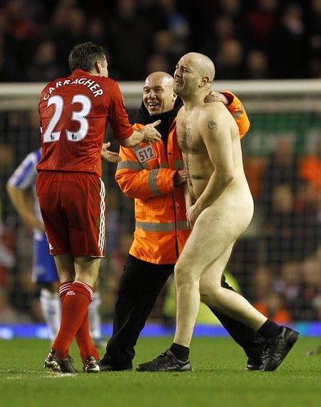 **EDITORS PLEASE NOT NUDITY** Liverpool's Jamie Carragher (left) talks to a streaker as he is lead away by a steward