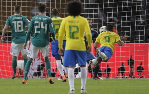 Brazil's Gabriel Jesus, right, scores the opening goal past Germany goalkeeper Kevin Trapp, 2nd right, during the international friendly soccer match between Germany and Brazil in Berlin, Germany, Tuesday, March 27, 2018. (AP Photo/Markus Schreiber)