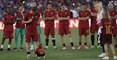 Roma's Francesco Totti looks down to his younger daughter Isabel, while his teammates and his wife Ilary and other daughter Chanel, right, look on as he addresses his fans after an Italian Serie A soccer match between Roma and Genoa at the Olympic stadium in Rome, Sunday, May 28, 2017. Francesco Totti played his final match with Roma against Genoa after a 25-season career with his hometown club. (AP Photo/Alessandra Tarantino) an Italian Serie A soccer match between Roma and Genoa at the Olympic stadium in Rome, Sunday, May 28, 2017. Francesco Totti is playing his final match with Roma against Genoa after a 25-season career with his hometown club. (AP Photo/Alessandra Tarantino)