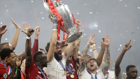 Liverpool's goalkeeper Alisson lifts the trophy as celebrates with his teammates after winning the Champions League final soccer match between Tottenham Hotspur and Liverpool at the Wanda Metropolitano Stadium in Madrid, Sunday, June 2, 2019. Liverpool won 2-0. (AP Photo/Felipe Dana)