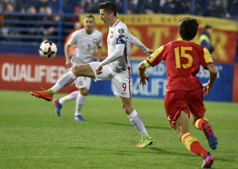 Poland's Robert Lewandowski, left, challenges Montenegro's Stefan Savic, during their World Cup Group E qualifying soccer match at the City Stadium in Podorica, Montenegro, Sunday, March 26, 2017. (AP Photo/Risto Bozovic)