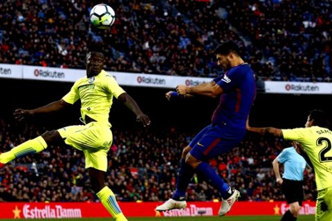 FC Barcelona's Luis Suarez, center, heads for the ball during the Spanish La Liga soccer match between FC Barcelona and Getafe at the Camp Nou stadium in Barcelona, Spain, Sunday, Feb. 11, 2018. (AP Photo/Manu Fernandez)