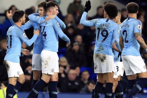 Manchester City's Aymeric Laporte, third left, celebrates scoring his side's first goal of the game with teammates during their English Premier League soccer match against Everton at Goodison Park, Liverpool, England, Wednesday, Feb. 6, 2019. (Peter Byrne/PA via AP)