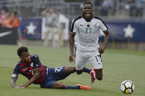 Ghana's Lumor Agbenyenu is tripped by United States' Kellyn Acosta, left, during the first half of an international friendly soccer match at Pratt & Whitney Stadium at Rentschler Field, Saturday, July 1, 2017, in East Hartford, Conn. The USA won 2-1. (AP Photo/Jessica Hill)