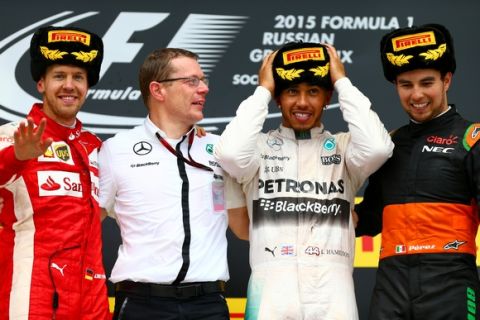 SOCHI, RUSSIA - OCTOBER 11:  Lewis Hamilton of Great Britain and Mercedes GP celebrates on the podium next to Sebastian Vettel of Germany and Ferrari and Sergio Perez of Mexico and Force India after winning the Formula One Grand Prix of Russia at Sochi Autodrom on October 11, 2015 in Sochi, Russia.  (Photo by Dan Istitene/Getty Images)