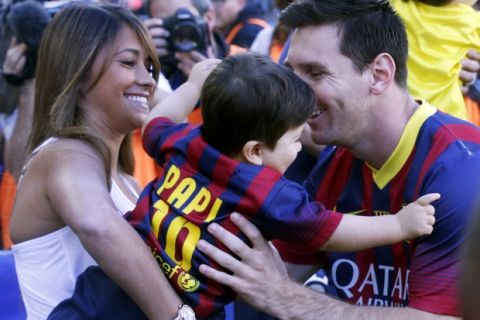 Barcelona's Lionel Messi (R) takes his soon Thiago from his partner Antonella Roccuzzo (L) before the La Liga soccer match against Getafe at Camp Nou stadium in Barcelona May 3, 2014.  REUTERS/Albert Gea (SPAIN - Tags: SPORT SOCCER) - RTR3NNXW