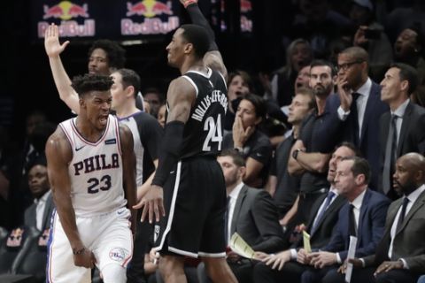 Philadelphia 76ers' Jimmy Butler (23) reacts after sinking a game-winning three point shot over Brooklyn Nets Rondae Hollis-Jefferson (24) in the fourth quarter of an NBA basketball game, Sunday, Nov. 25, 2018, in New York. The 76ers won 127-125. (AP Photo/Mark Lennihan)
