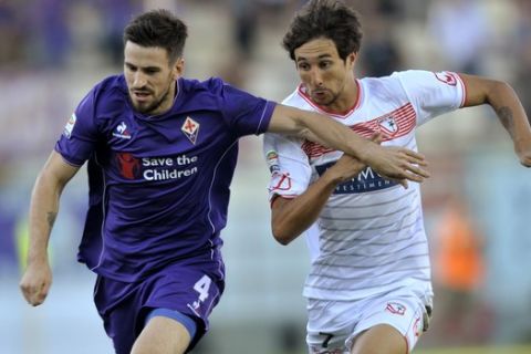 Carpi's Ryder Matos, right, vies for the ball with Fiorentina's Nenad Tomovic, during their Serie A soccer match at Modena's Braglia stadium, Italy, Sunday, Sept. 20, 2015. (AP Photo/Marco Vasini)