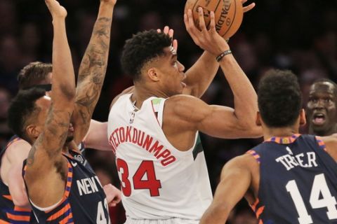 Milwaukee Bucks' Giannis Antetokounmpo, center, looks to pass during the first half of the NBA basketball game against the New York Knicks, Tuesday, Dec. 25, 2018, in New York. (AP Photo/Seth Wenig)