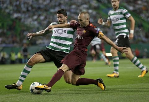 Barcelona's Andres Iniesta, right, challenges for the ball with Sporting's Cristiano Piccini during a Champions League, Group D soccer match between Sporting CP and FC Barcelona at the Alvalade stadium in Lisbon, Wednesday Sept. 27, 2017. (AP Photo/Armando Franca)
