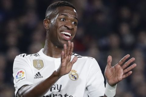 Real forward Vinicius Junior gestures after a misunderstanding with teammate Karim Benzema during the Copa del Rey semifinal first leg soccer match between FC Barcelona and Real Madrid at the Camp Nou stadium in Barcelona, Spain, Wednesday Feb. 6, 2019. (AP Photo/Emilio Morenatti)