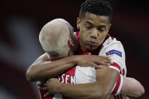 Ajax's David Neres, right, celebrates with teammate Davy Klaassen after Klaassen scored his side's first goal during the Europa League round of 16 first leg soccer match between Ajax and Young Boys at the Johan Cruyff ArenA in Amsterdam, Netherlands, Thursday, March 11, 2021. (AP Photo/Peter Dejong)