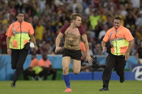 A pitch invader runs on the pitch during the final football match between Germany and Argentina for the FIFA World Cup at The Maracana Stadium in Rio de Janeiro on July 13, 2014.  AFP PHOTO / JUAN MABROMATA