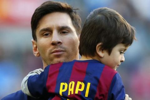 EDS NOTE : SPANISH LAW REQUIRES THAT THE FACES OF MINORS ARE MASKED IN PUBLICATIONS WITHIN SPAIN FC Barcelona's Lionel Messi, from Argentina, holds his son Thiago prior to a Spanish La Liga soccer match between FC Barcelona and Real Sociedad at the Camp Nou stadium in Barcelona, Spain, Saturday, Nov. 28, 2015. (AP Photo/Manu Fernandez)