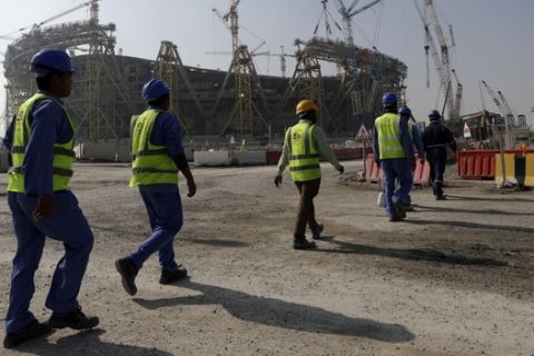 Workers walk to the Lusail Stadium, one of the 2022 World Cup stadiums, in Lusail, Qatar, Friday, Dec. 20, 2019. Construction is underway to complete Lusail's 80,000-seat venue for the opening game and final in a city that didn't exist when Qatar won the FIFA vote in 2010. (AP Photo/Hassan Ammar)