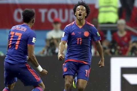 Colombia's Juan Cuadrado, right, celebrates after scoring his side's 3rd goal during the group H match between Poland and Colombia at the 2018 soccer World Cup at the Kazan Arena in Kazan, Russia, Sunday, June 24, 2018. (AP Photo/Thanassis Stavrakis)