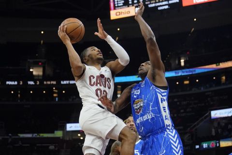 Cleveland Cavaliers guard Sharife Cooper (00) goes to the basket in front of Maccabi Ra'anana's Julien Ducree, right, in the second half of a preseason NBA basketball game Monday, Oct. 16, 2023, in Cleveland. (AP Photo/Sue Ogrocki)