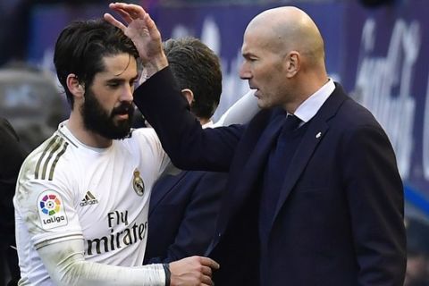 Real Madrid's Isco, left, talks with Real Madrid's head coach Zinedine Zidane after being substituted during the Spanish La Liga soccer match between Osasuna and Real Madrid at El Sadar stadium in Pamplona, northern Spain, Sunday, Feb. 9, 2020. (AP Photo/Alvaro Barrientos)