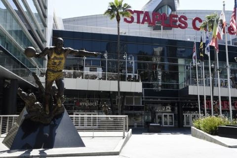 A statue of Los Angeles Lakers great Earvin "Magic" Johnson stands outside Staples Center, Tuesday, April 21, 2020, in Los Angeles. (AP Photo/Chris Pizzello)