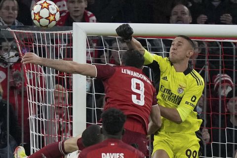 Benfica's goalkeeper Odysseas Vlachodimos pushes the ball away ahed of Bayern's Robert Lewandowski during the Champions League group E soccer match between Bayern Munich and Benfica Lisbon in Munich, Germany, Tuesday, Nov. 2, 2021.(AP Photo/Matthias Schrader)