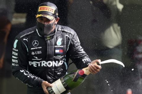 Mercedes driver Lewis Hamilton of Britain pours champagne and celebrates on the podium after winning the Formula One Grand Prix at the Spa-Francorchamps racetrack in Spa, Belgium, Sunday, Aug. 30, 2020. (Lars Baron, Pool via AP)