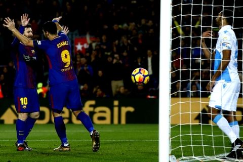 FC Barcelona's Luis Suarez, second left, celebrates after scoring with his teammate Lionel Messi during the Spanish La Liga soccer match between FC Barcelona and Deportivo Coruna at the Camp Nou stadium in Barcelona, Spain, Sunday, Dec. 17, 2017. (AP Photo/Manu Fernandez)