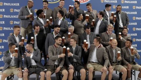 Bayern's players salut with beer in traditional Bavarian clothes during a photo shooting of a brewing company in Munich, Germany, Wednesday, Sept. 13, 2017. Mueller celebrates his 28th birthday today. (AP Photo/Matthias Schrader)