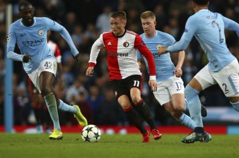 Feyenoord's Sam Larsson, center, is challenged by Manchester City's Yaya Toure, left, and Kevin De Bruyne, 2nd right, during the Champions League group F soccer match between Manchester City and Feyenoord, at the Etihad Stadium in Manchester, England, Tuesday, Nov. 21, 2017. (AP Photo/Dave Thompson)