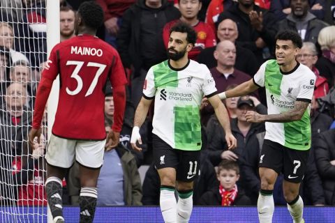 Liverpool's Mohamed Salah, centre, celebrates after scoring his side's second goal during the FA Cup quarterfinal soccer match between Manchester United and Liverpool at the Old Trafford stadium in Manchester, England, Sunday, March 17, 2024. (AP Photo/Dave Thompson)