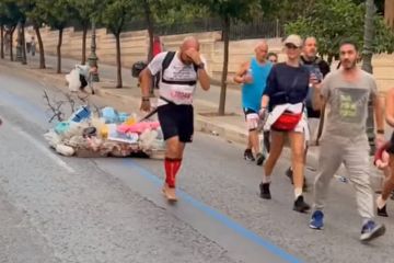 Έτρεξε ξανά στον Μαραθώνιο της Αθήνας χωρίς παπούτσια τραβώντας μια πλαστική μάζα από σκουπίδια κι ένα καμένο δέντρο