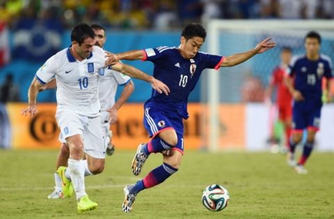 NATAL, BRAZIL - JUNE 19:  Giorgos Karagounis of Greece challenges Shinji Kagawa of Japan during the 2014 FIFA World Cup Brazil Group  C match between Japan and Greece at Estadio das Dunas on June 19, 2014 in Natal, Brazil.  (Photo by Jamie McDonald/Getty Images)
