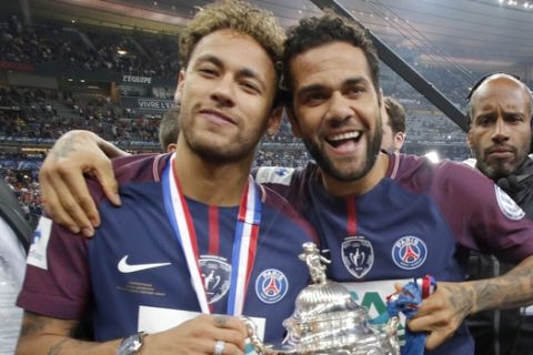 PSG's Neymar, left, and his teammate Dani Alves pose with the French Cup 2018 trophy at the Stade de France stadium in Saint-Denis, outside Paris, Tuesday, May 8, 2018. Paris Saint-Germain beat resilient third-division side Les Herbiers 2-0 to win the French Cup. (AP Photo/Michel Euler) PSG's Presnel Kimpembe