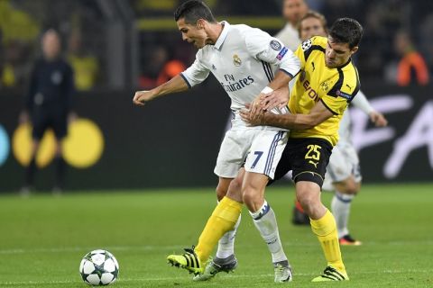 Real Madrid's Cristiano Ronaldo, left, and Dortmund's Sokratis Papastathopoulos challenge for the ball during the Champions League group F soccer match between Borussia Dortmund and Real Madrid in Dortmund, Germany, Tuesday, Sept. 27, 2016. (AP Photo/Martin Meissner)