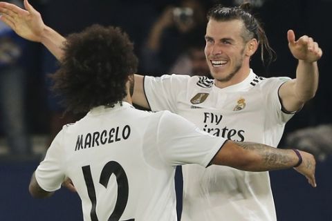 Real Madrid's midfielder Gareth Bale celebrates with teammate Marcelo, left, after scoring his side's third goal during the Club World Cup semifinal soccer match between Real Madrid and Kashima Antlers at Zayed Sports City stadium in Abu Dhabi, United Arab Emirates, Wednesday, Dec. 19, 2018. (AP Photo/Kamran Jebreili)