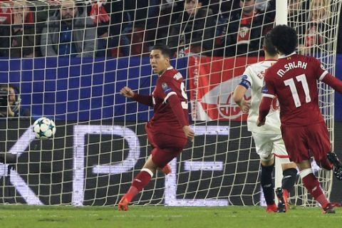 Liverpool's Roberto Firmino, left, scores his side's third goal during a Champions League group E soccer match between Sevilla and Liverpool, at the Ramon Sanchez Pizjuan stadium in Seville, Spain, Tuesday, Nov. 21, 2017. (AP Photo/Miguel Morenatti)