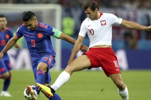 Colombia's Radamel Falcao, left, and Poland's Grzegorz Krychowiak, right, challenge for the ball during the group H match between Poland and Colombia at the 2018 soccer World Cup at the Kazan Arena in Kazan, Russia, Sunday, June 24, 2018. (AP Photo/Thanassis Stavrakis)