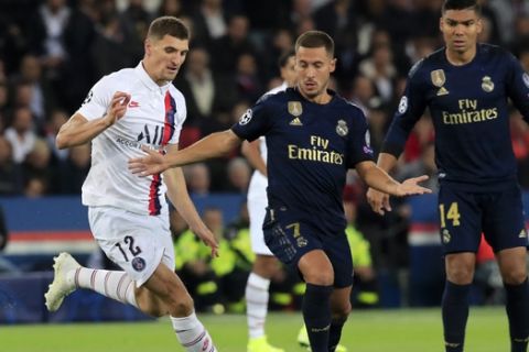 Real Madrid's Eden Hazard vies for the ball with PSG's Thomas Meunier, left, during the Champions League group A soccer match between PSG and Real Madrid at the Parc des Princes stadium in Paris, Wednesday, Sept. 18, 2019. (AP Photo/Michel Euler)