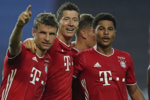 Bayern's Serge Gnabry, right, celebrates his side's second goal with teammates Robert Lewandowski, center, and Thomas Mueller during the Champions League semifinal soccer match between Lyon and Bayern Munich at the Jose Alvalade stadium in Lisbon, Portugal, Wednesday, Aug. 19, 2020. (Miguel A. Lopes/Pool via AP)