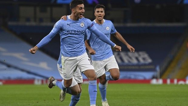 Manchester City's Ferran Torres, left, celebrates scoring his sides third goal during the Champions League group C soccer match between Manchester City and FC Porto at the Etihad stadium in Manchester, England, Wednesday, Oct. 21, 2020. (Paul Ellis/Pool via AP)