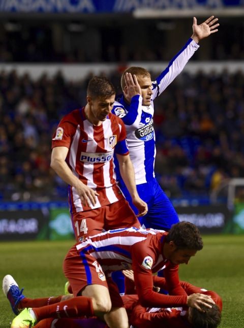 In this photo taken Thursday March 2, 2017, Atletico Madrid's Fernando Torres is helped by team mates as Deportivo La Coruna's Alex Bergantinos, top right calls for help after they clashed with their heads during a La Liga soccer match at the Riazor stadium in La Coruna, Spain. Atletico Madrid says Torres has been released from the hospital Friday following a scary head-to-head clash which left him unconscious and that a CAT scan did not reveal any damage to his head or neck after knocking heads with Deportivo La Coruna midfielder Alex Bergantinos. (AP Photo/Carlos Pardellas)