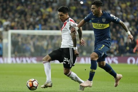 Cristian Pavon of Argentina's Boca Juniors, right, challenges for the ball Enzo Perez of Argentina's River Plate during the Copa Libertadores final soccer match at the Santiago Bernabeu stadium in Madrid, Spain, Sunday, Dec. 9, 2018. (AP Photo/Manu Fernandez)