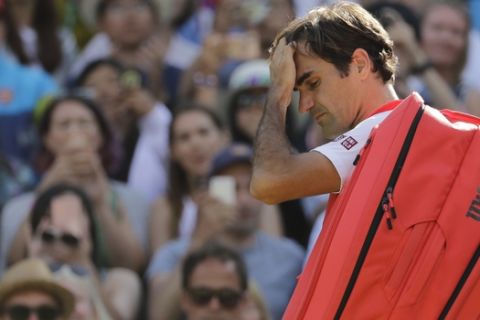 Switzerland's Roger Federer leaves the court after losing his men's quarterfinals match against Kevin Anderson of South Africa, at the Wimbledon Tennis Championships, in London, Wednesday July 11, 2018. (AP Photo/Ben Curtis)