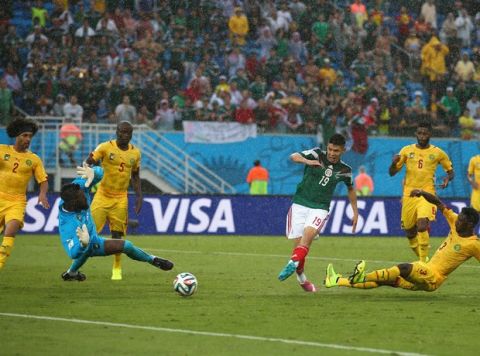 NATAL, BRAZIL - JUNE 13: Oribe Peralta of Mexico shoots and scores a goal past Charles Itandje of Cameroon in the second half during the 2014 FIFA World Cup Brazil Group A match between Mexico and Cameroon at Estadio das Dunas on June 13, 2014 in Natal, Brazil.  (Photo by Julian Finney/Getty Images)
