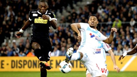 Angers' Karl Toko Ekambi, left, challenges for the ball with Marseille's William Vainqueur, during the League One soccer match between Marseille and Angers, at the Velodrome Stadium, Friday, March 10, 2017. (AP Photo/Claude Paris)
